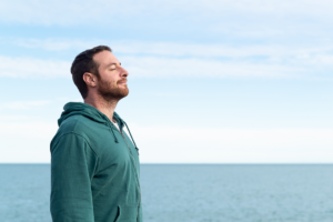 man freed from depression standing by the ocean