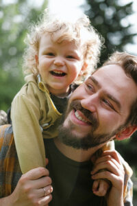 happy man with happy child on his shoulder