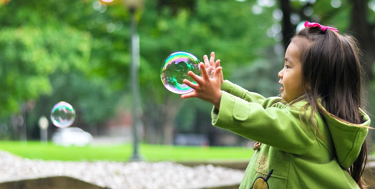 girl playing with a large bubble